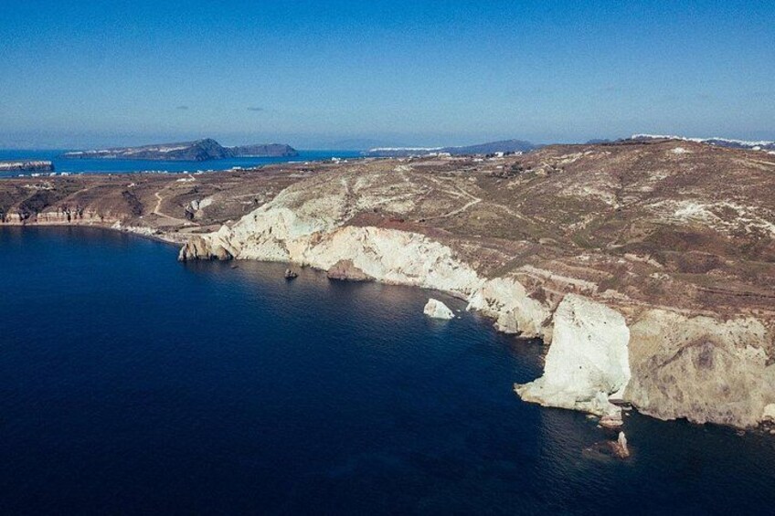 A coastal landscape with cliffs, a bay, and distant landforms. 3