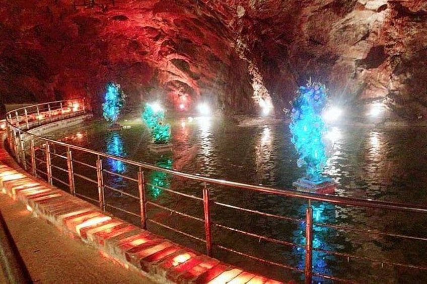 En grotta med en vatteninstallation och upplysta skulpturer. 5