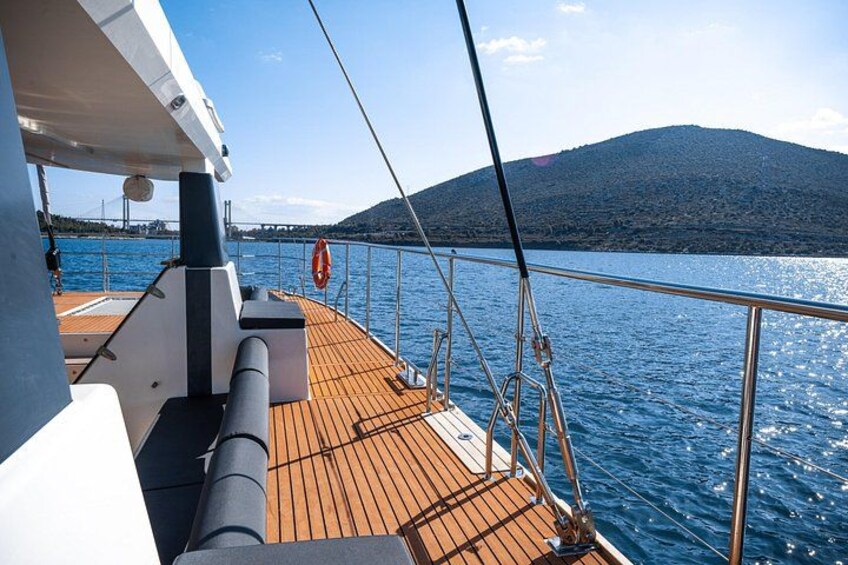 Ein Bootsdeck mit Holzboden, Metallgeländern und einem Rettungsring. 3