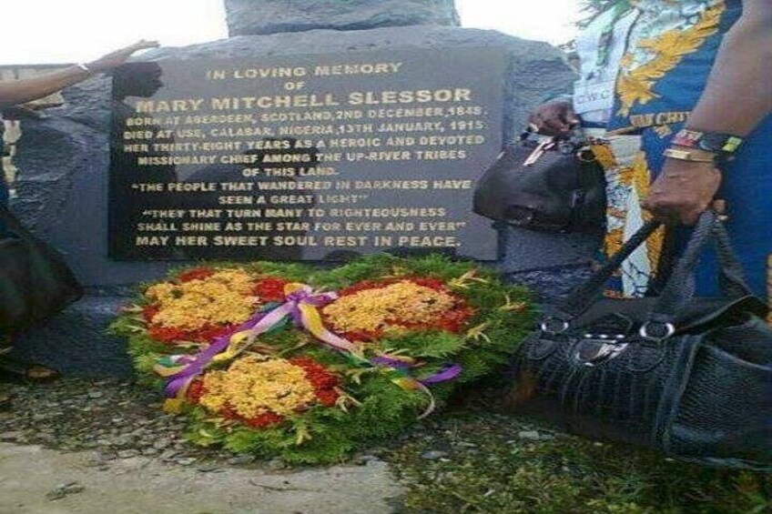 A memorial stone with inscriptions and flowers. 5