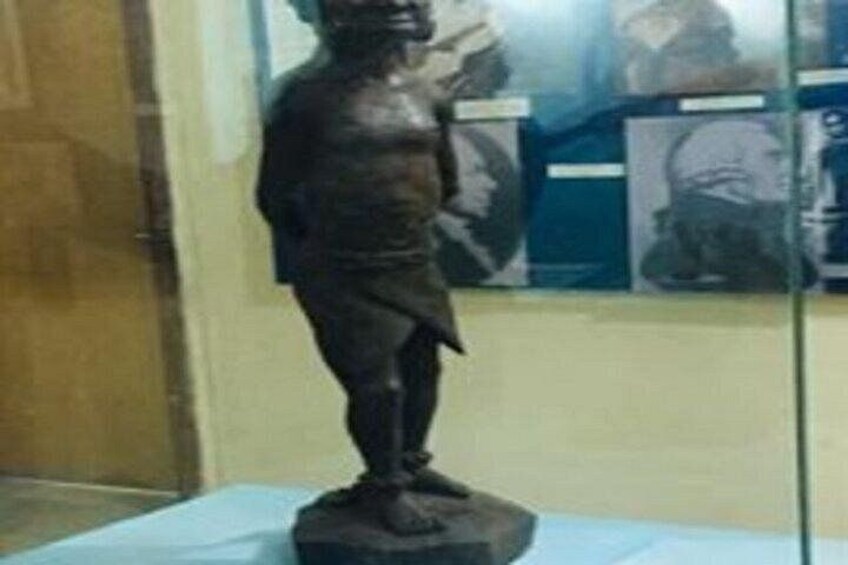 A statue of a man on a pedestal in a museum. 3