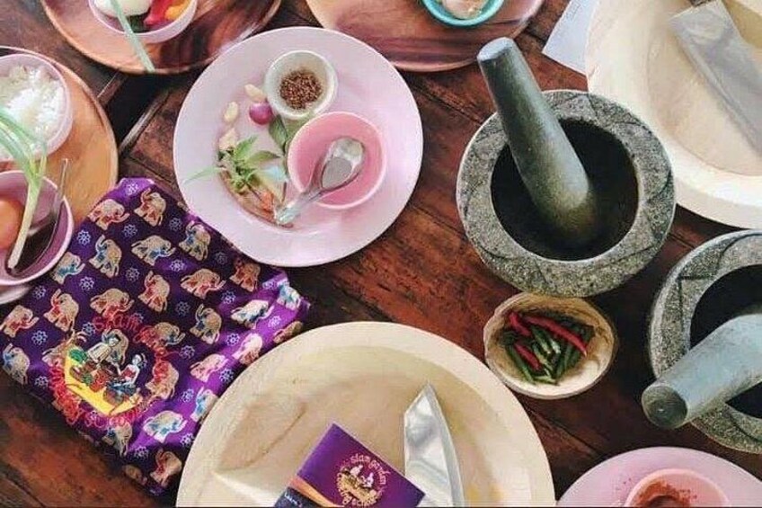 A table with various dishes, chopsticks, a bowl of rice, and a mortar and pestle. 2