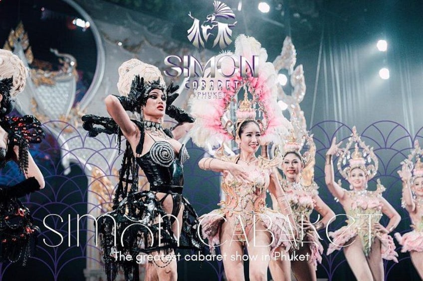 A cabaret show with performers in elaborate costumes and a large, ornate stage backdrop. 1