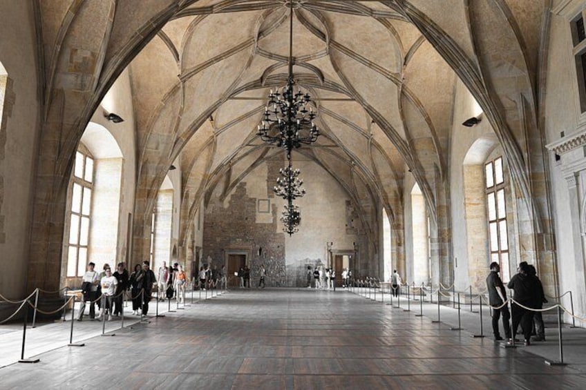 A spacious hall with high vaulted ceilings and a central chandelier. 3