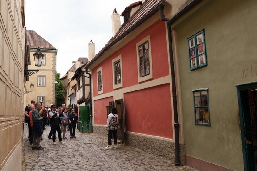 Une rue pavée bordée de bâtiments historiques, un groupe de personnes et une porte verte. 4