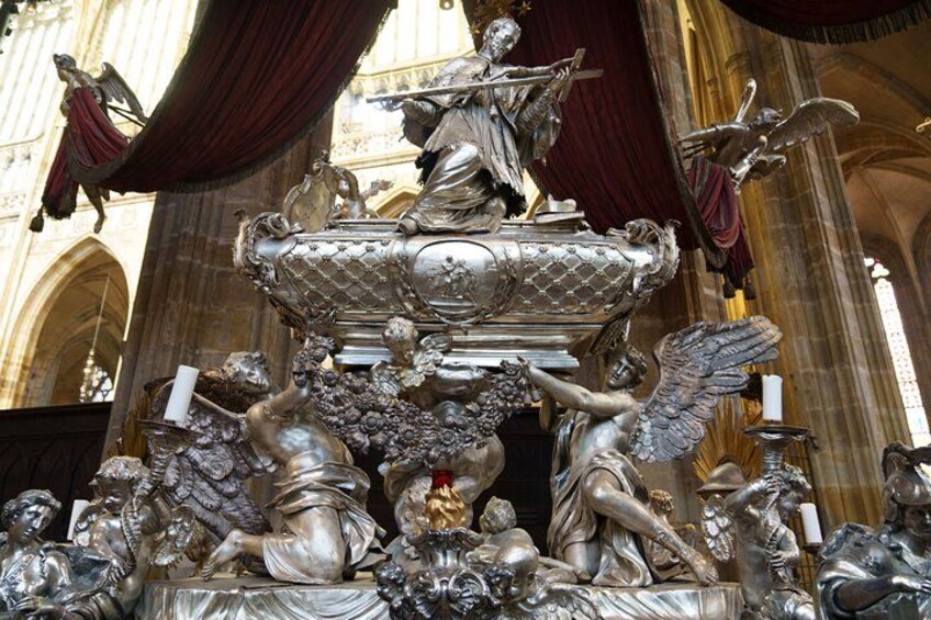 Eine silberne, kunstvoll verzierte Brunnenanlage mit Engeln und Cherubs, vor der Kulisse einer Kathedrale. 5