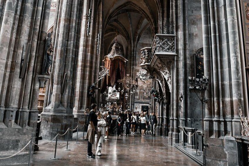 A cathedral interior with high vaulted ceilings, large stone columns, and a central altar with religious statues. 4