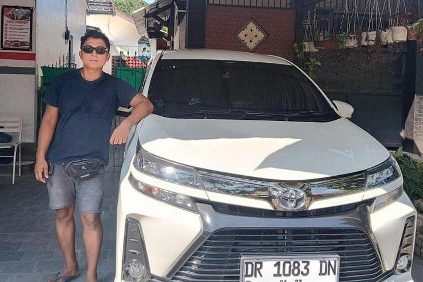 A white Toyota car parked in front of a building with a signboard. 4