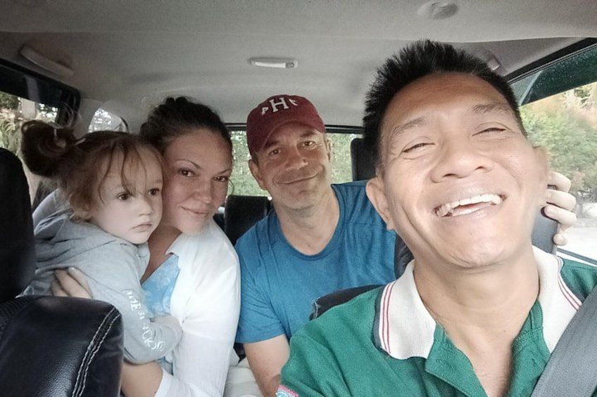 A family in a car with a child in the front seat. 2
