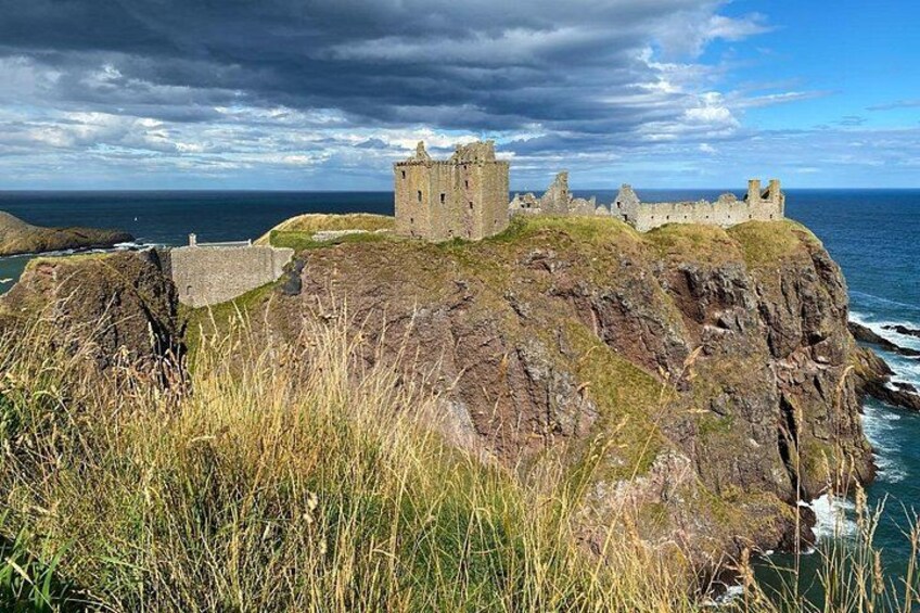A coastal castle on a rocky cliff with the ocean in the background. 3