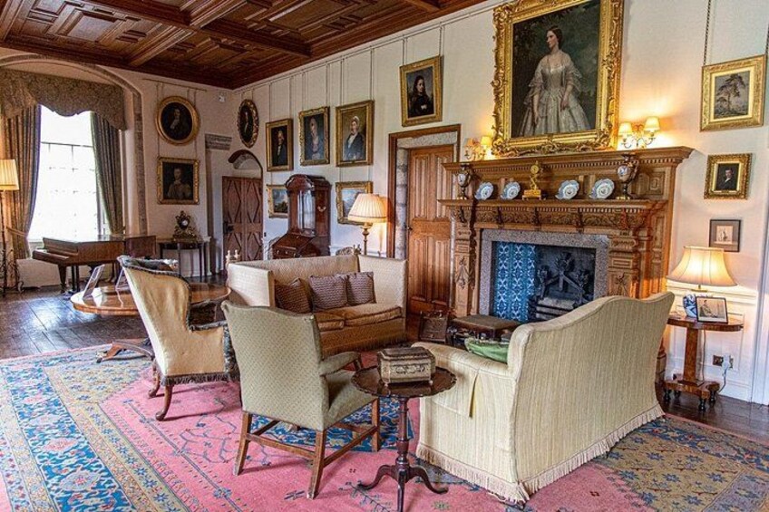 A traditional room with a fireplace, ornate furniture, and a large portrait on the wall. 4