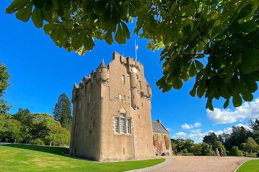 Un château doté d’une tour, entouré d’une pelouse bien entretenue et d’arbres. 3
