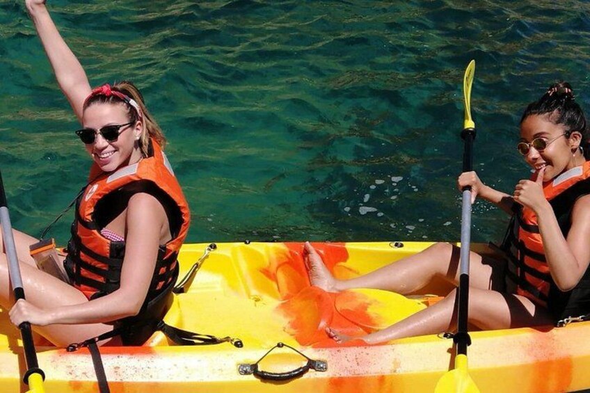 Two people kayaking in a yellow raft on clear water. 3