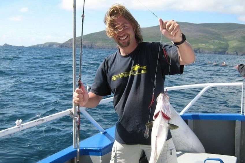 A person on a boat holding a fish. 1