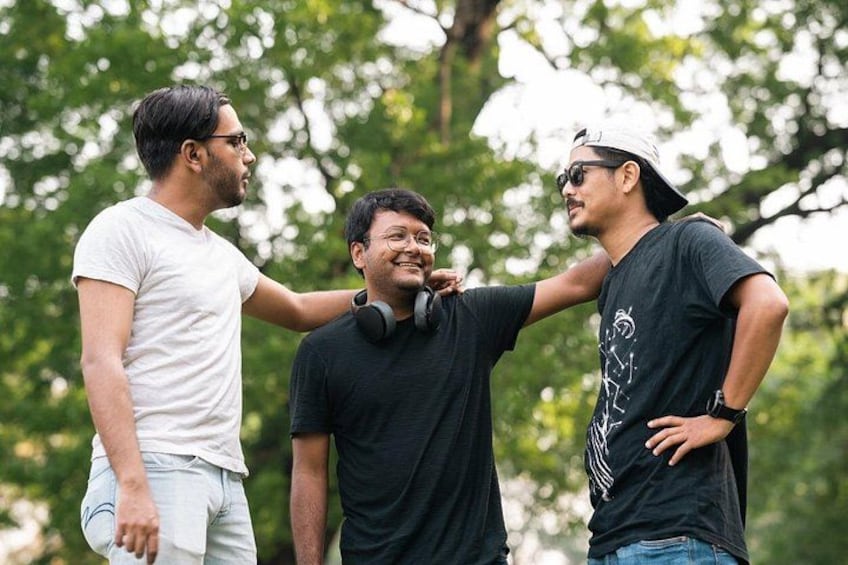 Three people standing outdoors with trees in the background. 5