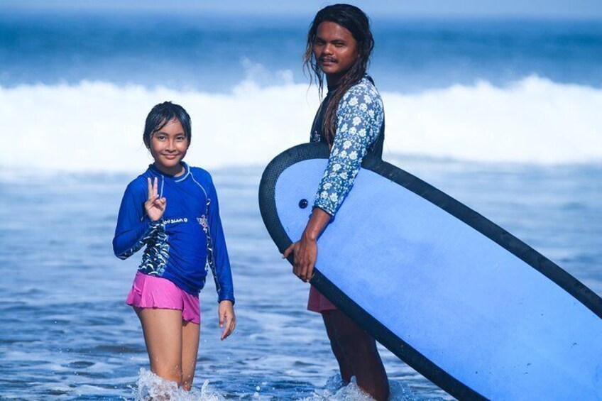 Two people walking in the ocean with surfboards. 3
