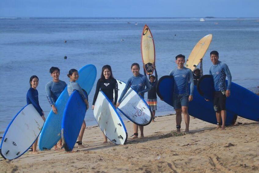 A group of people on a beach holding surfboards. 5