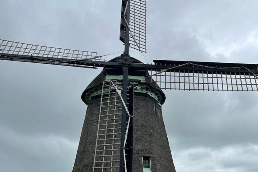 Un molino de viento con estructura de celosía y una puerta verde. 5