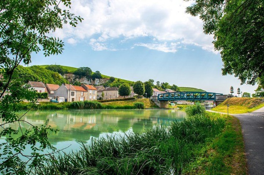 Ein ruhiger Fluss mit Häusern und einer Brücke. 3