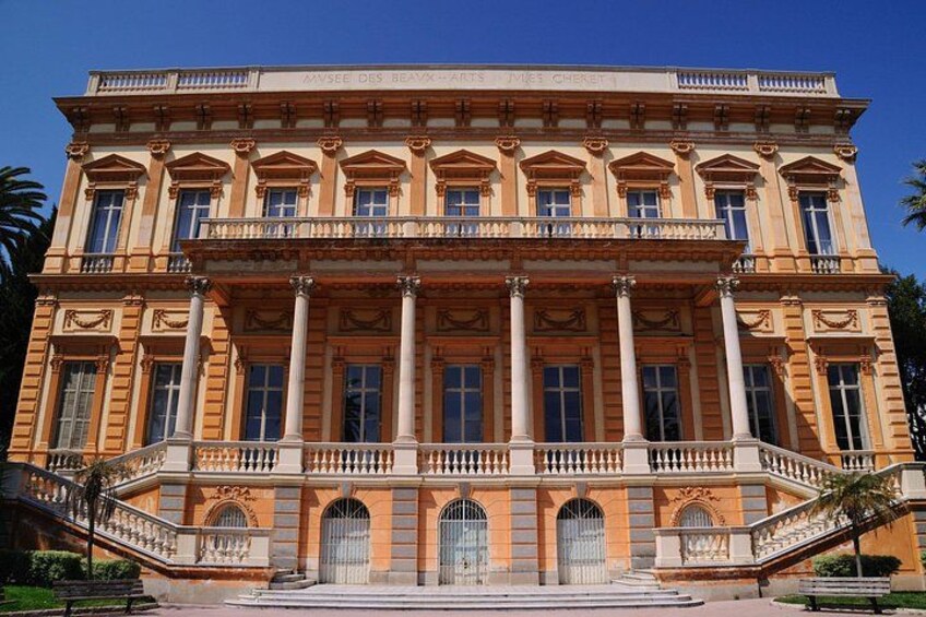 A large, ornate building with a grand entrance, columns, and a balcony. 2