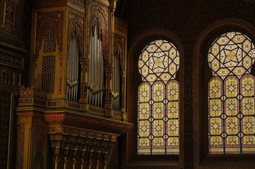 Vidrieras ornamentales y un órgano de tubos en un edificio histórico. 4