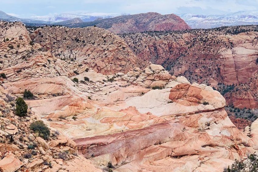 A rugged mountain landscape with layered rock formations and sparse vegetation. 2