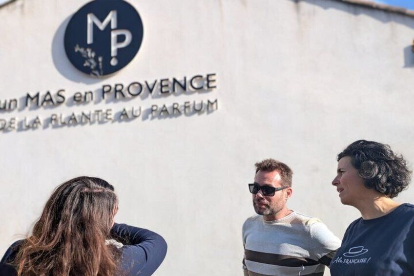 A group of people standing in front of a sign with 'MAS en PROVENCE' and 'DE LA FLANTE AU PARFUM' written on it. 3