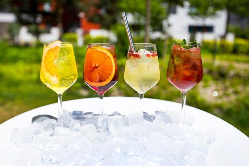 Four colorful cocktails on a white table with ice, outdoors. 3