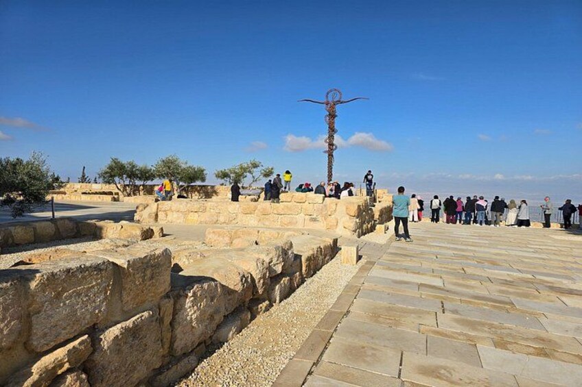 Ancient ruins with stone walls and a metal sculpture. 4