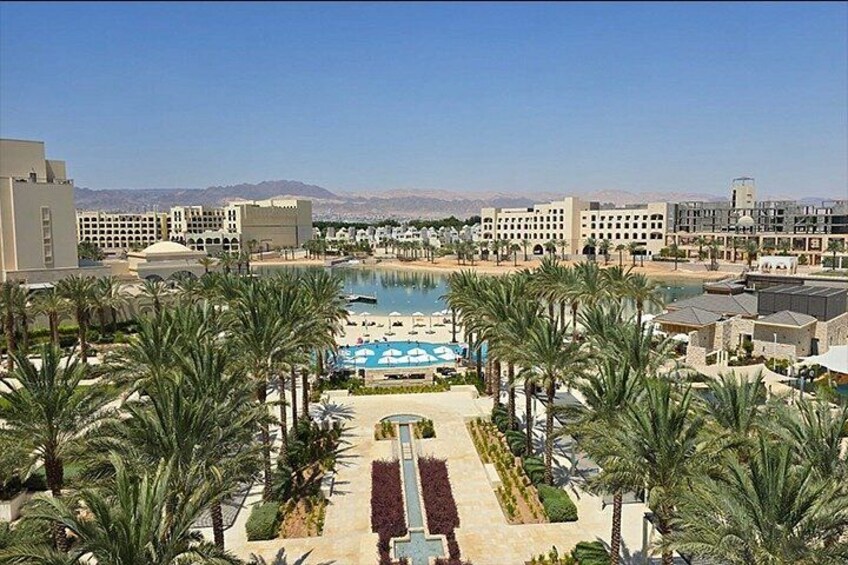 A resort with a pool, palm trees, and buildings. 3