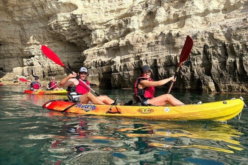 People kayaking on a river with rocky cliffs in the background. 2