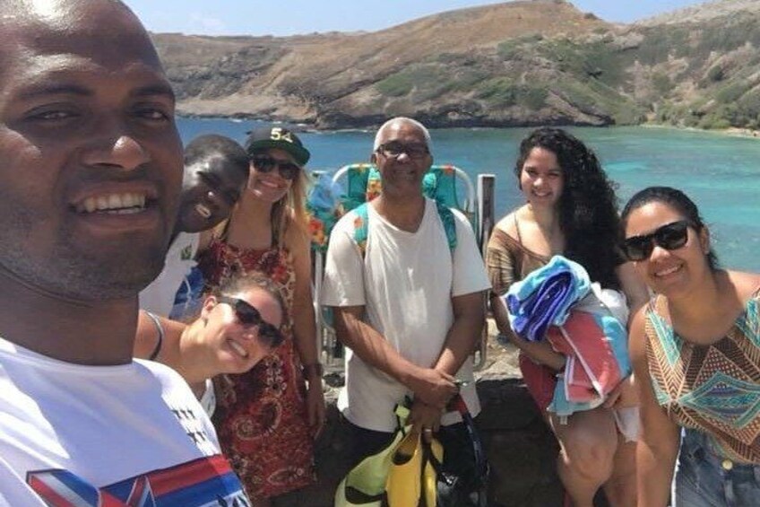 A group of people on a boat with a mountainous landscape in the background. 1