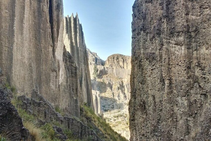 A canyon with steep rock faces and a waterfall. 4