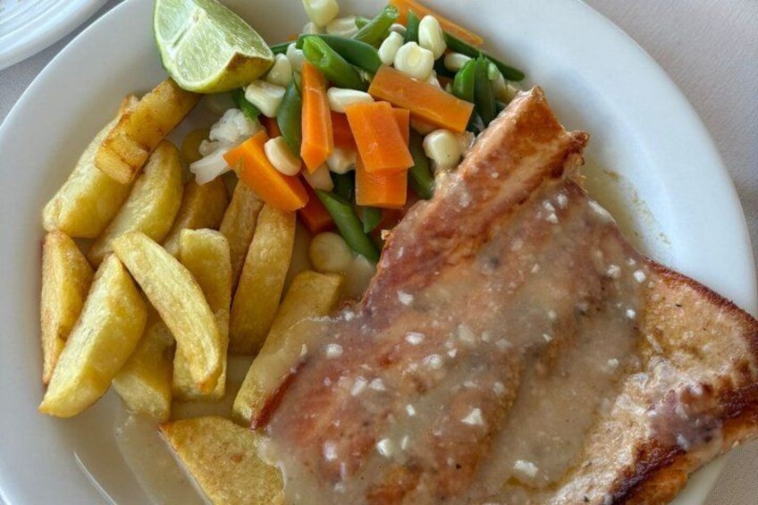 A plate with fried fish, French fries, and a side salad. 5