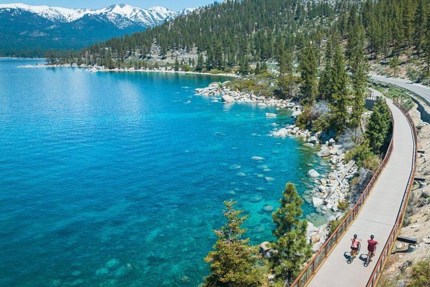 A clear blue lake with a winding road and a trail. 2