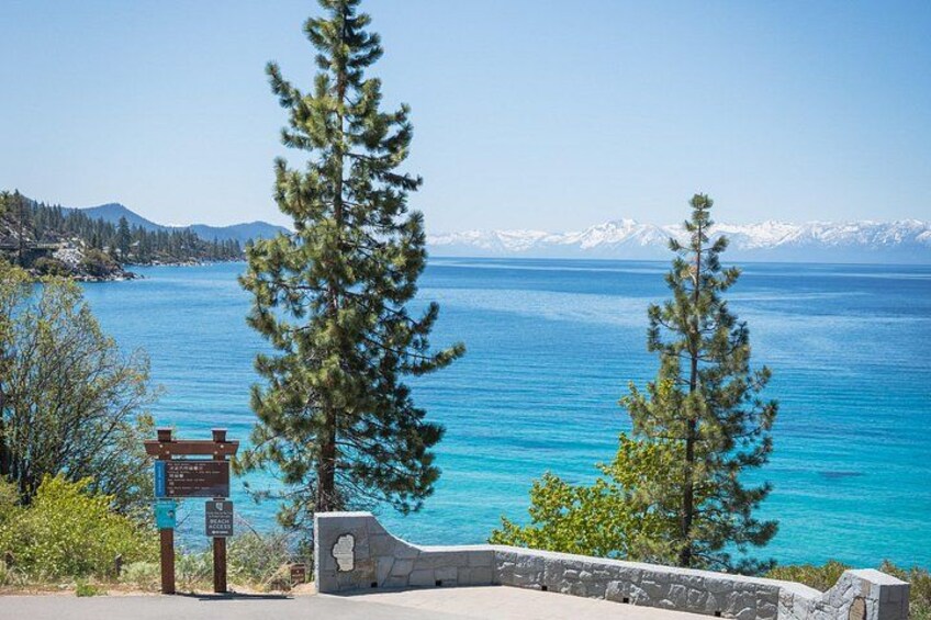 A lake with clear blue water, surrounded by mountains and trees. 5