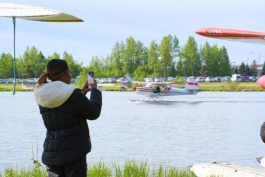 Guests taking photo of float plane taxing on water 4