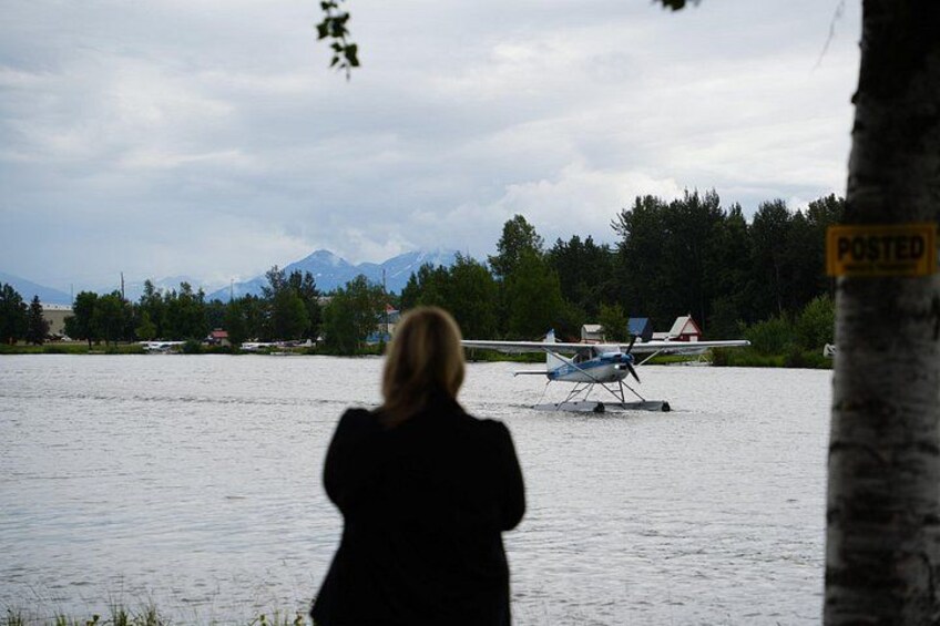 Guest taking photo of float plane landing on water 3