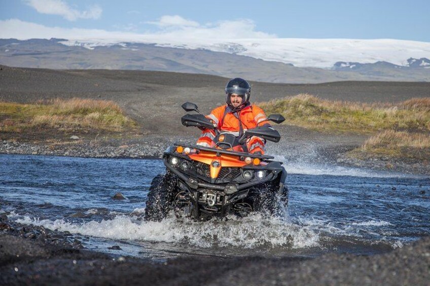 Una persona conduciendo un cuatrimoto por un río. 2