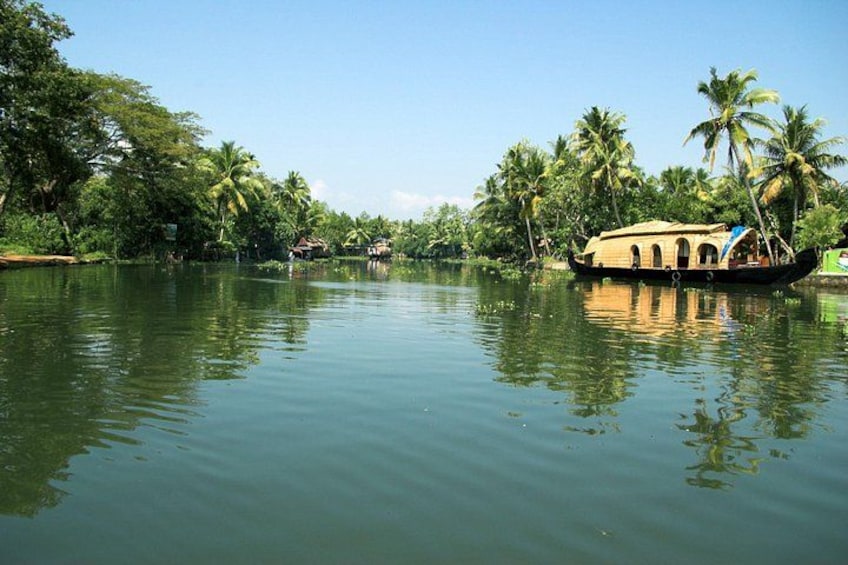 A calm river with a traditional boat and palm trees. 5