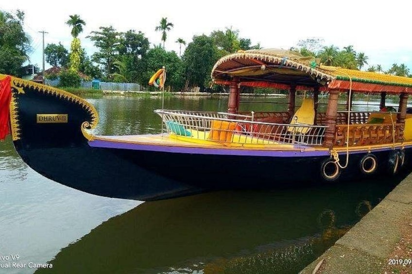 A traditional boat with a covered deck, a nameplate, and a railing. 2