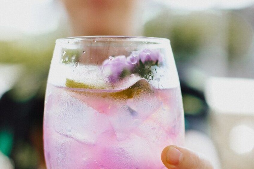 Een glas roze drank met ijsblokjes en een schijfje limoen. 4