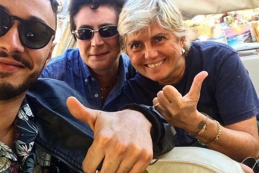 Tres personas sentadas juntas, una gesticulando con la mano. 2