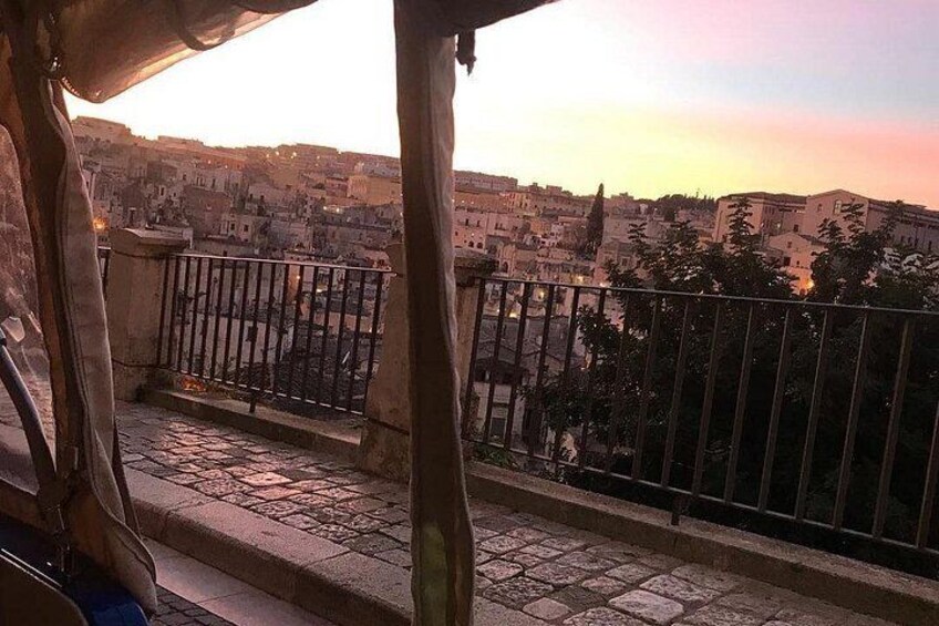 Un balcón con vistas a un paisaje urbano al atardecer. 3