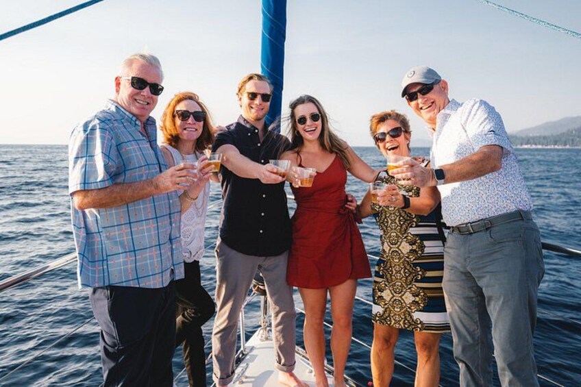 A group of people on a sailboat with a clear sky and calm sea. 1
