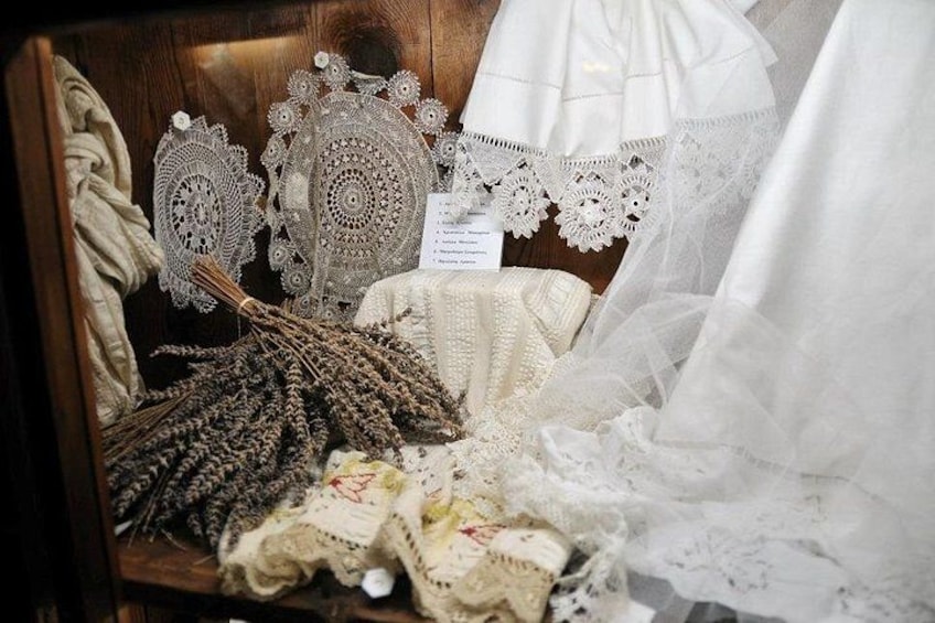 A display of white lace and crocheted items, including a lace doily and a crocheted blanket. 3