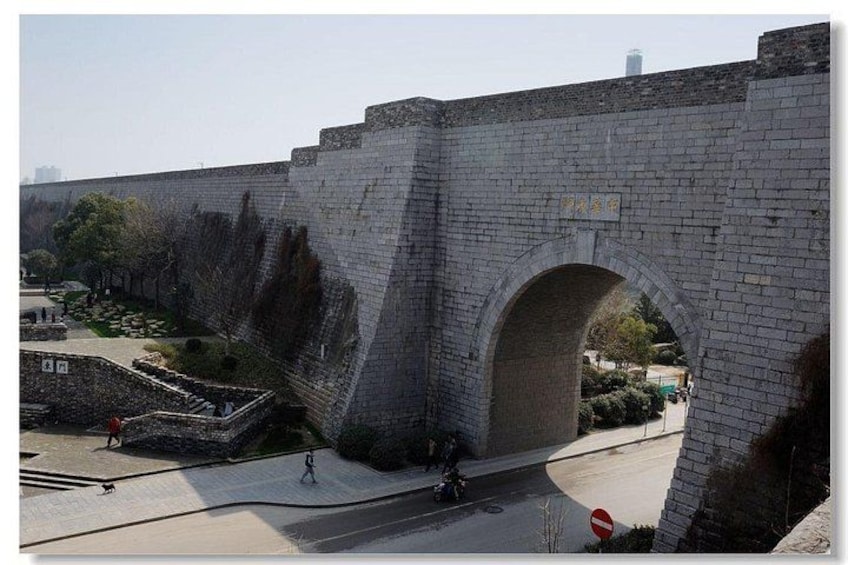 A stone bridge with an arch, a paved walkway, and a clear sky. 2