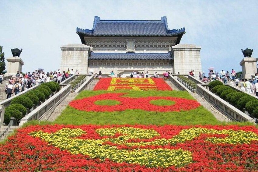 A traditional Korean gate with a large floral arrangement in front. 5