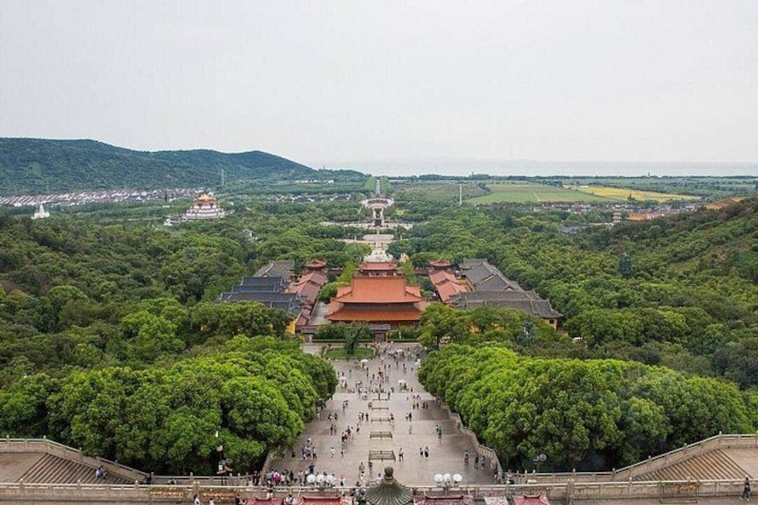 A traditional temple complex with a central building, surrounded by lush greenery and a large open courtyard. 1