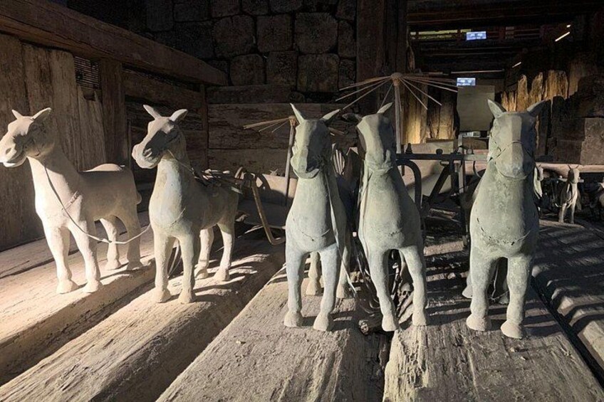A collection of horse statues in a rustic setting. 5
